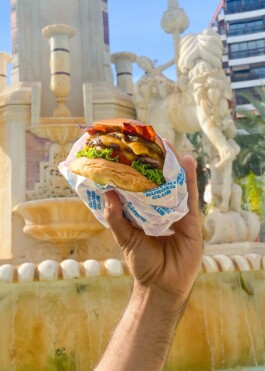 Mano sosteniendo una Burger en la Plaza de los Luceros Alicante 