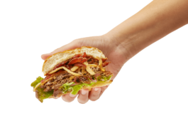 Mano enseñando la mitad de una burger de Bulla Burgers Alicante 